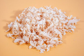 Close-up of wood shavings, with a detailed texture and natural lighting