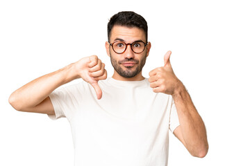 Young handsome caucasian man over isolated chroma key background making good-bad sign. Undecided...