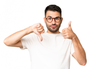 Young handsome caucasian man over isolated chroma key background making good-bad sign. Undecided between yes or not