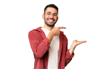 Young handsome caucasian man over isolated chroma key background holding copyspace imaginary on the palm to insert an ad