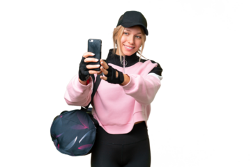 Pretty sport woman with sport bag over isolated chroma key background making a selfie