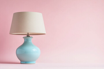 A vintage brass table lamp with a fluted cream shade placed on a solid  background.