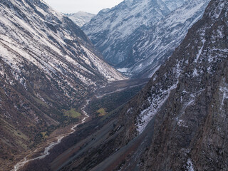 A mountain river, a stream meanders among the slopes of the mountain. Winter landscape, meadow and...