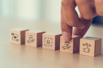 Exceptional service concept. Wooden blocks with exceptional service icons. Providing a positive,...