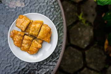 Top view of a signature dish of Pontianak, Indonesia called srikaya fried banana on a glass table