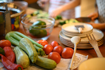the kitchen, chopping mushrooms, cucumbers, and tomatoes. Together, they prepare ingredients for a...