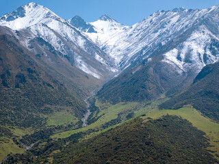 A mountain river, a stream meanders among the slopes of the mountain. Summer landscape, meadow and...