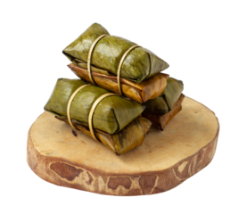 Thai dessert, sweet sticky rice topped with banana, beans or taro. In Thai, it is called Khao Tom Mat. Wrapped and steamed in banana leaves. Khao Tom Mat is separated on a white background.