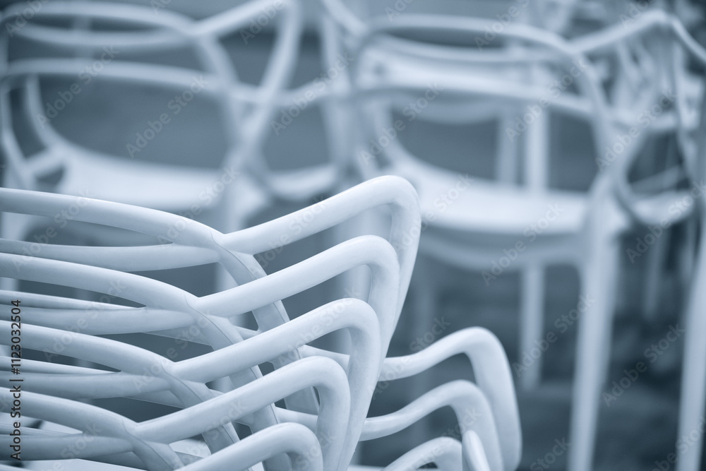 Poster a row of white chairs are arranged in a line. the chairs are all facing the same direction
