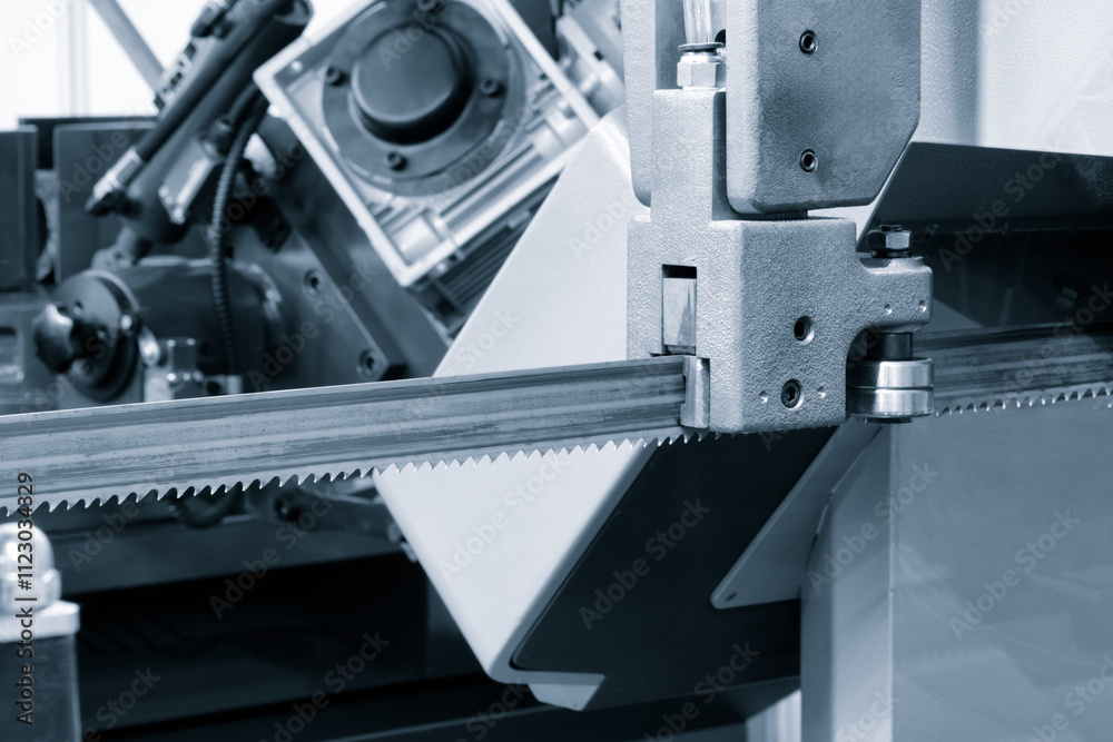 Poster a machine with a blade cutting through a piece of metal. the blade is sharp and has a serrated edge
