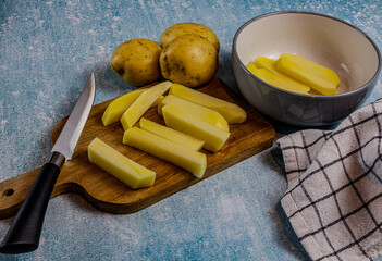 Preparing , cutting chips on a wooden chopping board