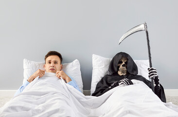 Scared man lying in bed beside grim reaper, who holds scythe and visiting for kill. This horror...
