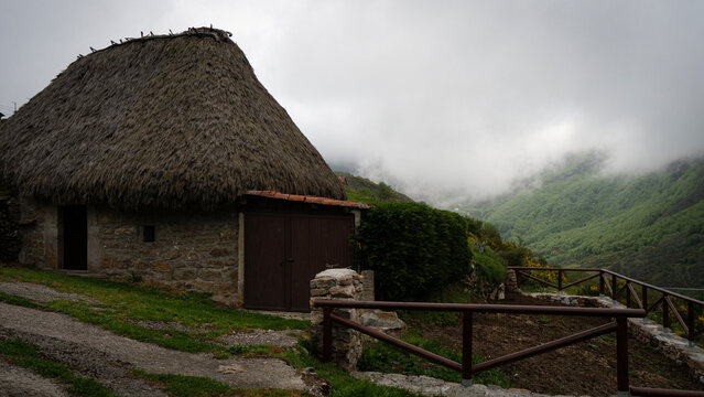 Typical asturian h&oacute;rreo overlooking foggy mountains in rural spain