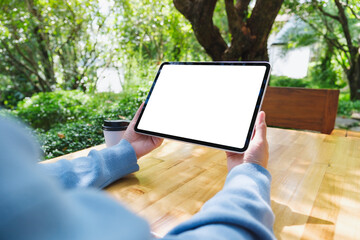 Mockup image of a woman holding digital tablet with blank white desktop screen in the outdoors