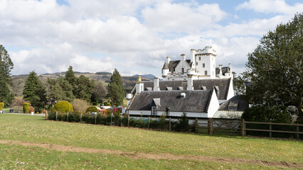Blair castle rising above the scottish countryside on a cloudy day