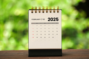 February 2025 - A desktop calendar for February 2025 with nature background, time and business...