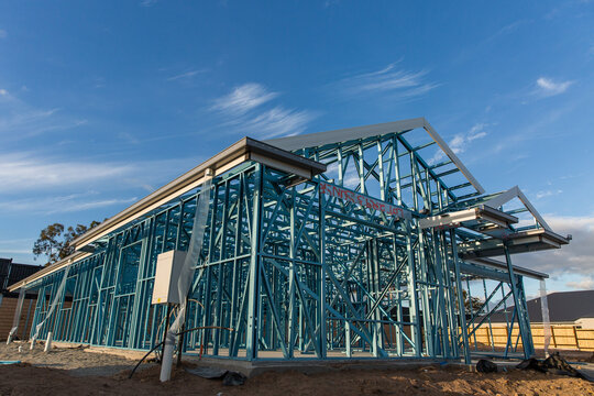 low angle shot of a house at frame stage under construction under a blue sky