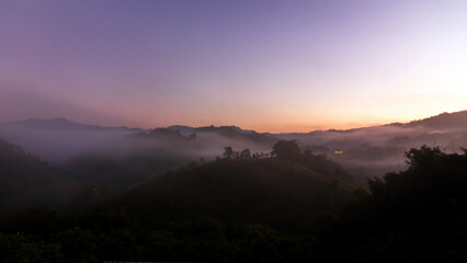 Obraz premium A serene landscape at dawn, showcasing misty hills under a soft gradient sky.