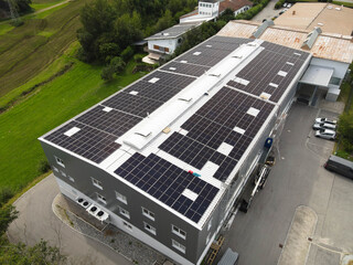 Drone View of a Large Industrial Facility with Solar Panels Installed on Its Metal Roof