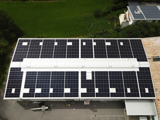 Drone View of a Large Industrial Facility with Solar Panels Installed on Its Metal Roof