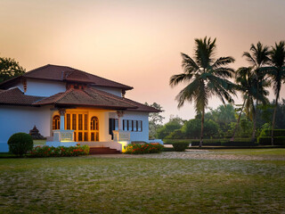 Elegant Kerala-style villa surrounded by lush greenery and serene landscapes. Showcasing traditional South Indian architecture with a harmonious connection to nature.