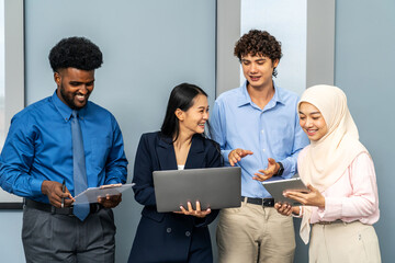 Group of happy multicultural architect business team people Standing in a meeting using a laptop, tablet and files to check work, working towards their shared goals, talking and smile