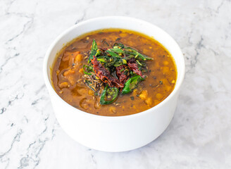 Spicy Dal Makhani topping with red and green chili served in bowl isolated on grey background side view of Pakistan and Indian food
