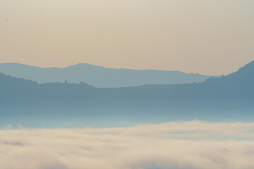 serene landscape featuring soft, layered mountains shrouded in mist, creating tranquil atmosphere....