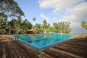 Swimming pool and decking in garden, Tropical resort hotel in Thailand 