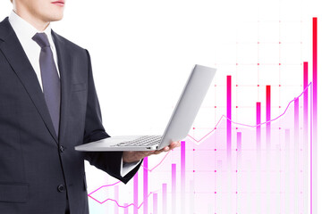 Businessman in suit holding laptop with pink graph chart overlay on white background. Concept of business, finance, and technology
