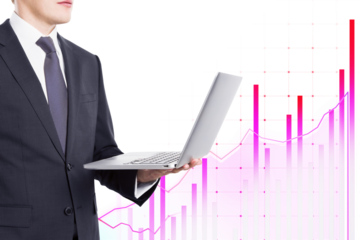 Businessman in suit holding laptop with pink graph chart overlay on white background. Concept of business, finance, and technology