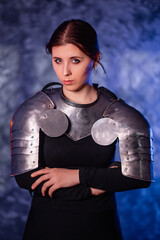 Portrait of a young woman with scars on her face, dressed in black clothes with steel knightly...
