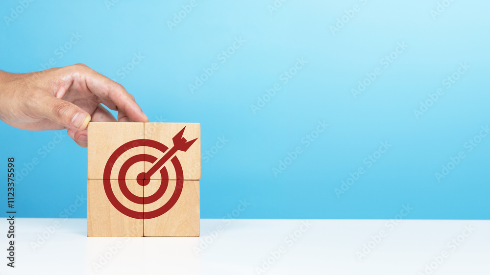 Wall mural Target, business success, successful goals. A man putting wooden blocks with target icon which is the last piece Indicating targets that were successful