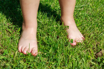 A baby's bare feet on green grass, capturing the innocence and joy of childhood discovery in nature on a warm day