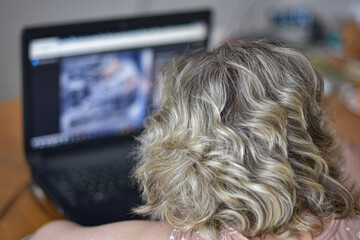 The girl looks at the laptop screen.