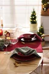 Christmas table setting with stylish dishware and festive decor indoors