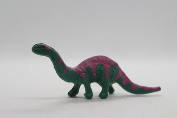 Pink and green Brontosaur figure isolated on a white background © TomKorcak