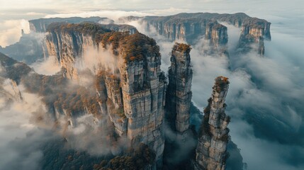 Majestic Stone Pillars Enveloped in Mist: Aerial View of a Mountain Range