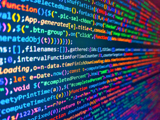 Website codes on monitor. Selective focus on the far end of the computer display out of focus in front. Web software development background. Background of program code. Color coding on screen.