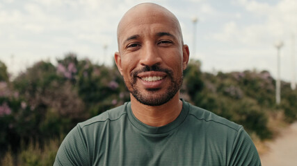 Close-up of strong man, fit guy in sportswear standing outdoors and looking in camera pensively. Motivation and dreams, success in sports, active lifestyle, training and healthy routine