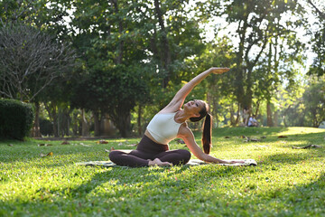 Happy mindful Asian woman wearing sportswear, meditating doing yoga breathing exercises, feeling...