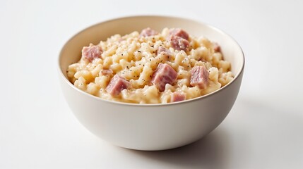Close-Up of Creamy Ham Risotto in an Off-White Bowl on a Minimalist Surface