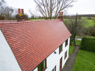 Brand new roof and tiles seen on an old English farmhouse in the UK. The original roof of the Grade...