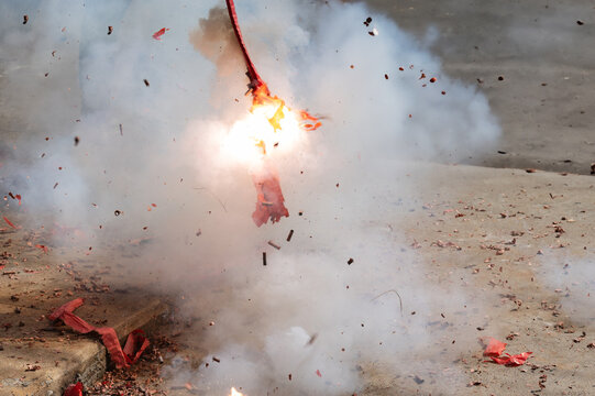 Red firecrackers exploding in the street for the chinese new year celebration day.Chinese New Year festival firecrackers with smoke.