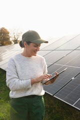 Female farmer with digital tablet on a modern farm using solar panels