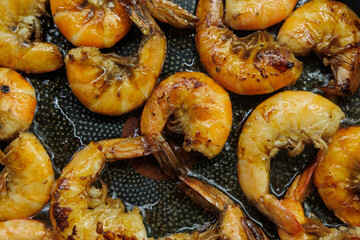 Golden pan-fried shrimp sizzling in a skillet, showcasing their rich, juicy texture