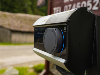 Electric car charging station around on street. Close-up of recharging sustainable transport.