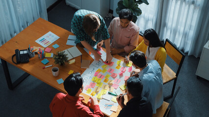 Top view of business people hands making scrum task board to manage workflow in workplace. Diverse...