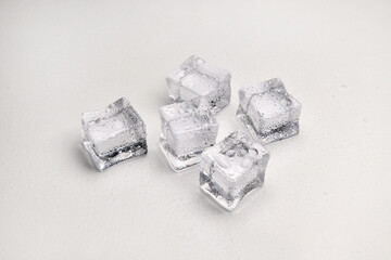 Crystal clear ice cubes melted with water droplets isolated on white background