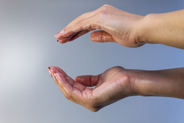 Artistic photography of female hands, hands and fingers, open and facing each other.